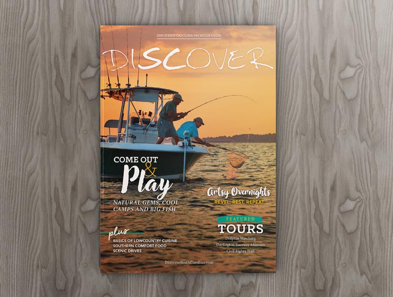 The cover of Discover South Carolina Magazine featuring two men fishing on a boat